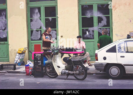 ATHENS, GREECE -  Man bargains at flea market in Psiri area street, Monastiraki, Athens Stock Photo