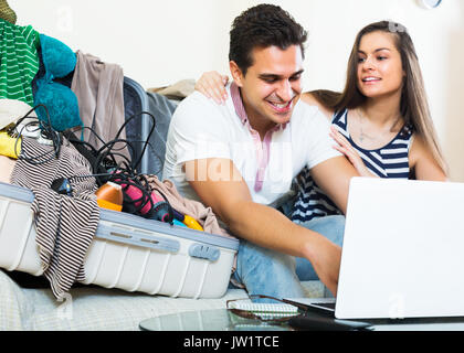 Smiling couple preparing for honeymoon and making planning list at home Stock Photo