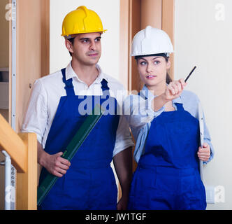Professional maintenance crew of two american specialists in helmets indoors Stock Photo