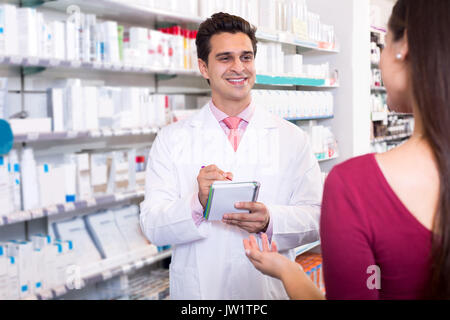Smiling experienced pharmacist counseling female customer Stock Photo ...