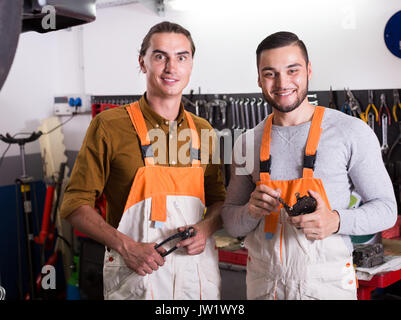 Two happy workmen toiling in the locksmiths workshop and smiling Stock Photo