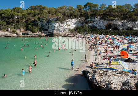 Swimmers and sunbathers enjoying a sunny day, Cala Llombards, Majorca, Spain Stock Photo