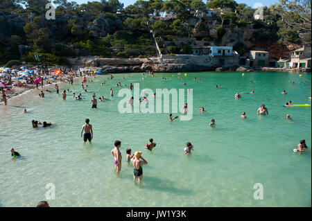 Swimmers and sunbathers enjoying a sunny day, Cala Llombards, Majorca, Spain Stock Photo