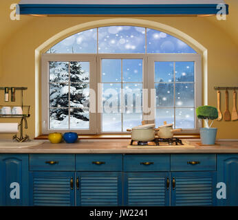 Interior blue kitchen. Preparing lunch at home on the kitchen stove with a view from the window on a snowy forest Stock Photo