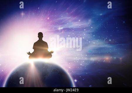 Silhouette man doing meditation against digitally composite image of colorful lights Stock Photo