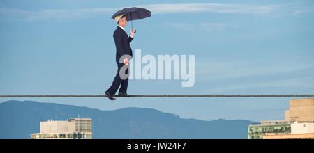 Businessman with umbrella walking on white background against buildings in city against blue sky Stock Photo