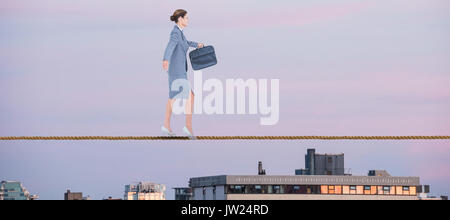 Businesswoman walking with briefcase over white background against city against sky during sunset Stock Photo