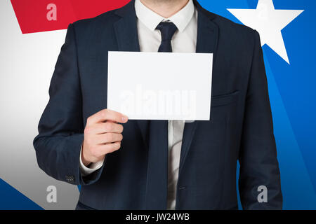 Businessman showing card to camera against digital composite of american flag Stock Photo