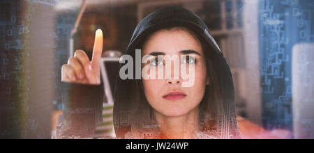 Young female hacker using digital screen against composite image of shiny spiral of binary code Stock Photo