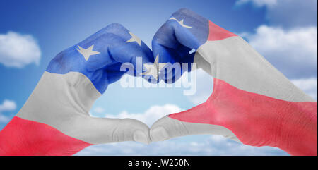 Woman making heart shape with hands against american flag with stars and stripes Stock Photo
