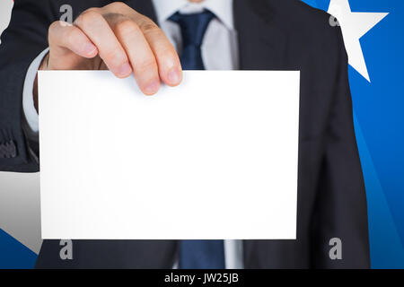 Mature businessman showing card against digital composite of american flag Stock Photo