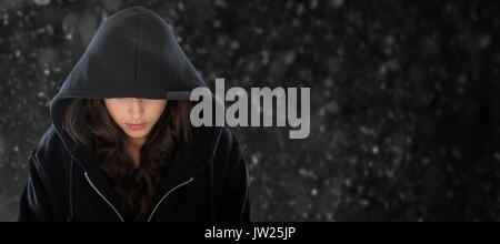 Female spy in hoodie against black background Stock Photo