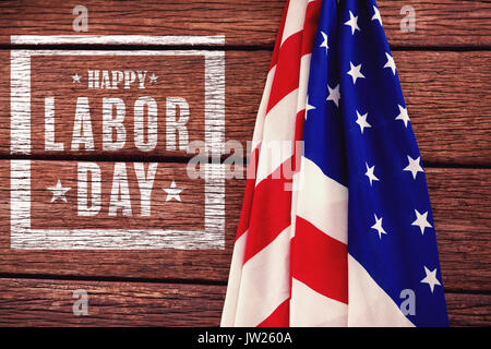 Composite image of happy labor day poster against american flag on a wooden table Stock Photo
