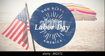 Happy labor day text on blue poster against beach umbrella at tropical sand beach Stock Photo