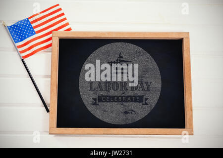 Digital composite image of celebrate labor day text with American flag on blue poster against blank chalkboard by american flag Stock Photo