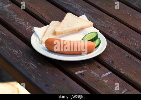 Bock sausage, wieners or Frankfurther sausage with toast and cucumbers on a white plate. Stock Photo