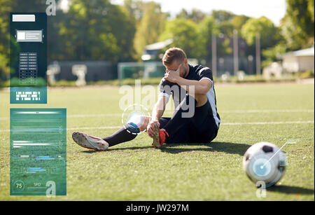 injured soccer player with ball on football field Stock Photo