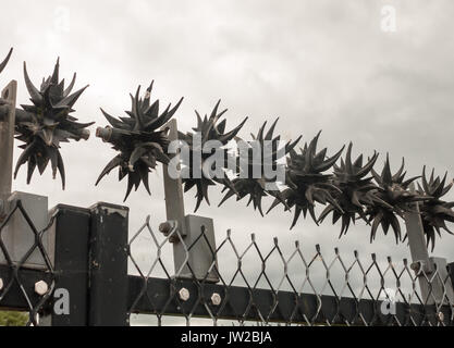 close up of metal spikes on fence protecting power grid; UK Stock Photo