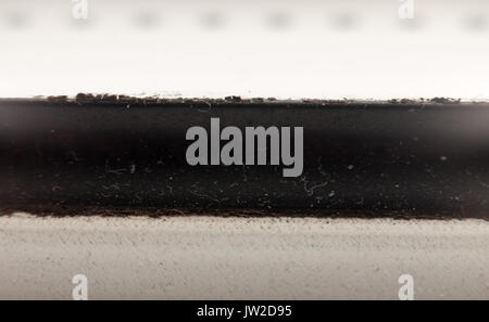 close up texture macro background of black strip through white background; UK Stock Photo