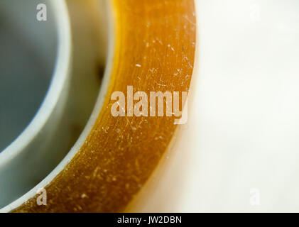 extreme close up of yellow sticker tape cellophane on white background; UK Stock Photo