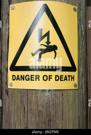 yellow danger of death sign on wooden post; UK Stock Photo