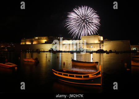 A firework explodes behind Fort St Angelo, Malta, during annual feast day celebrations in the town of Birgu (Vittoriosa) Stock Photo