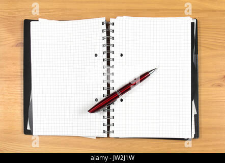 Open notebook with empty pages and pen on top Stock Photo