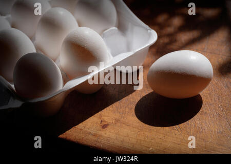 Fresh eggs in carton on table Stock Photo