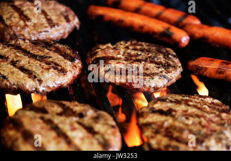 Hamburgers and hot dogs on barbeque grill Stock Photo