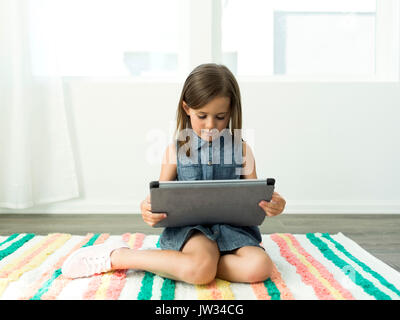 Girl (6-7) using digital tablet at home Stock Photo