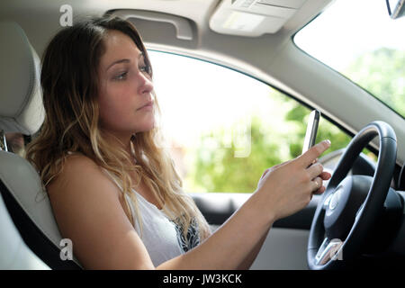 Woman using smartphone in car Stock Photo