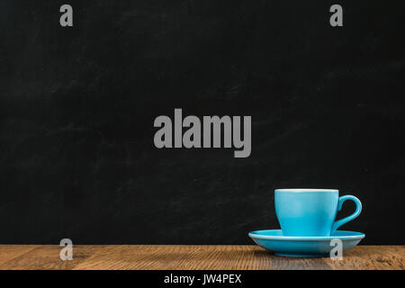 blue ceramic coffee cup set with blackboard wall background on wood texture retro desk in order to restaurant advertising drawing inspired design area Stock Photo