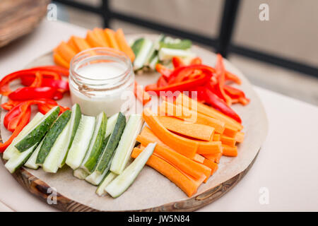 Fresh cucumber, carrot, red sweet paprika sliced in stripes on an olive wood cutting board Stock Photo