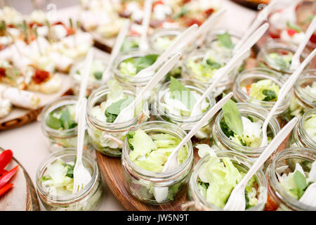 salad with tomatoes, green leafs and feta cheese in mason jars Stock Photo