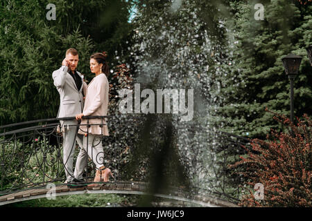 young beautiful couple walking in the Park and stands on the bridge Stock Photo