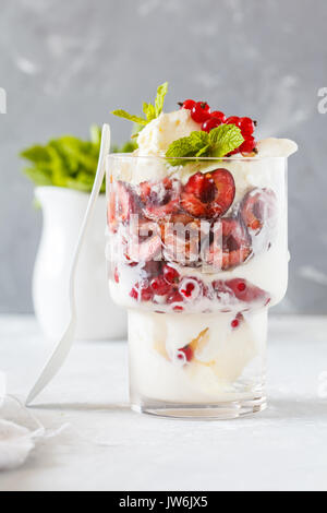 Homemade vanilla ice cream with berries in a glass. Love for a healthy vegan food concept. Stock Photo