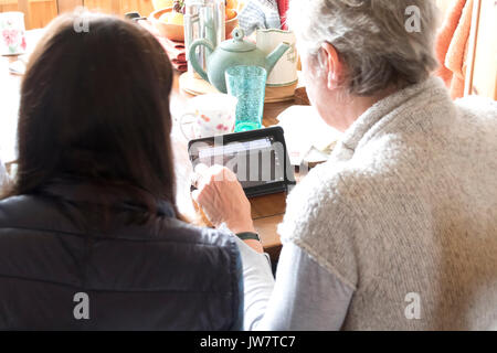 Two women looking at kindle Stock Photo