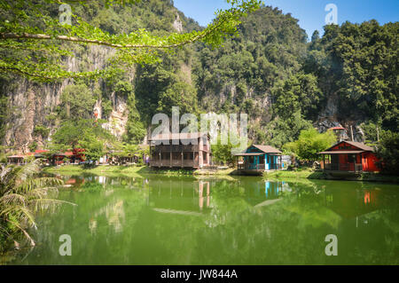 Water reflections of wooden houses with limestones on the background in the countryside of Ipoh city, Perak, Malaysia. South East Asia Stock Photo