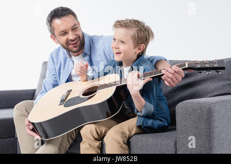 smiling father teaching his excited son to sing and play on guitar  Stock Photo