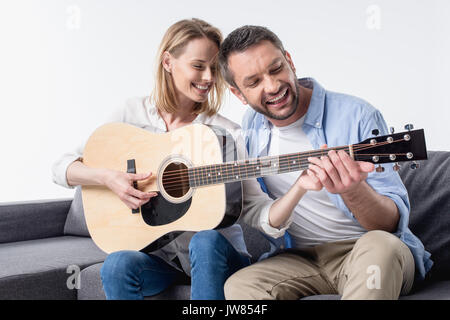 smiling man teaching woman playing acoustic guitar isolated on white  Stock Photo