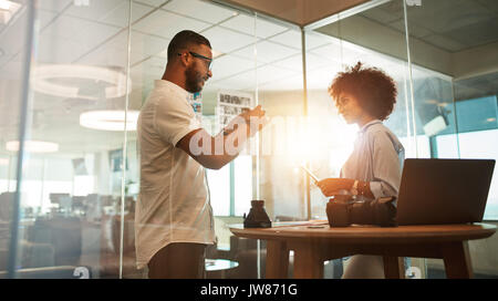 Two young photographers discussing creative ideas in office. Designers working together on new project. Stock Photo