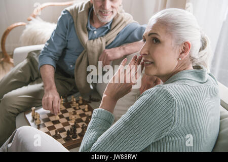 casual grey haired couple playing chess at home Stock Photo