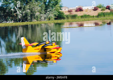 A floating Radio controlled model hydroplane speeds up to take off on Guadiana river, Badajoz Stock Photo