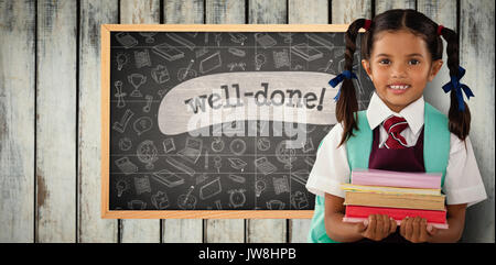 Smiling schoolgirl carrying books against well-done! against black background Stock Photo