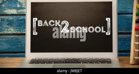 Back to school text over white background against laptop on table Stock Photo