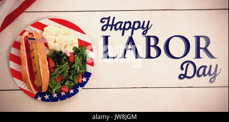 Poster of happy labor day text against hot dog with american flag in plate Stock Photo