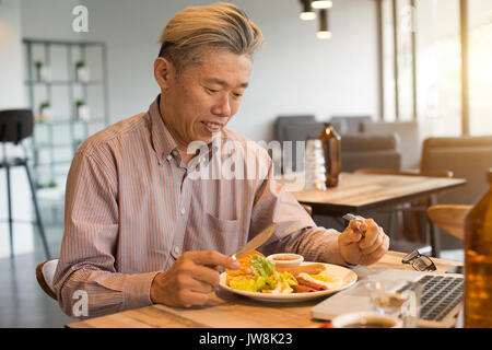 matured asian business male having breakfast Stock Photo