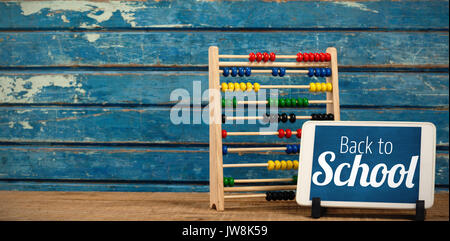 Back to school text over white background against digital tablet by abacus on table Stock Photo