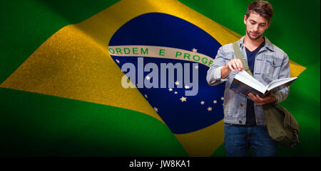 Student reading in library against digitally generated brazil national flag Stock Photo