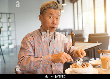 matured asian business male having breakfast Stock Photo